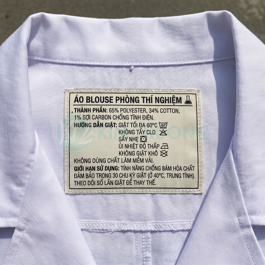 Nhãn áo blouse phòng thí nghiệm ghi thành phần polyester, cotton và sợi carbon chống tĩnh điện, cùng hướng dẫn giặt ủi